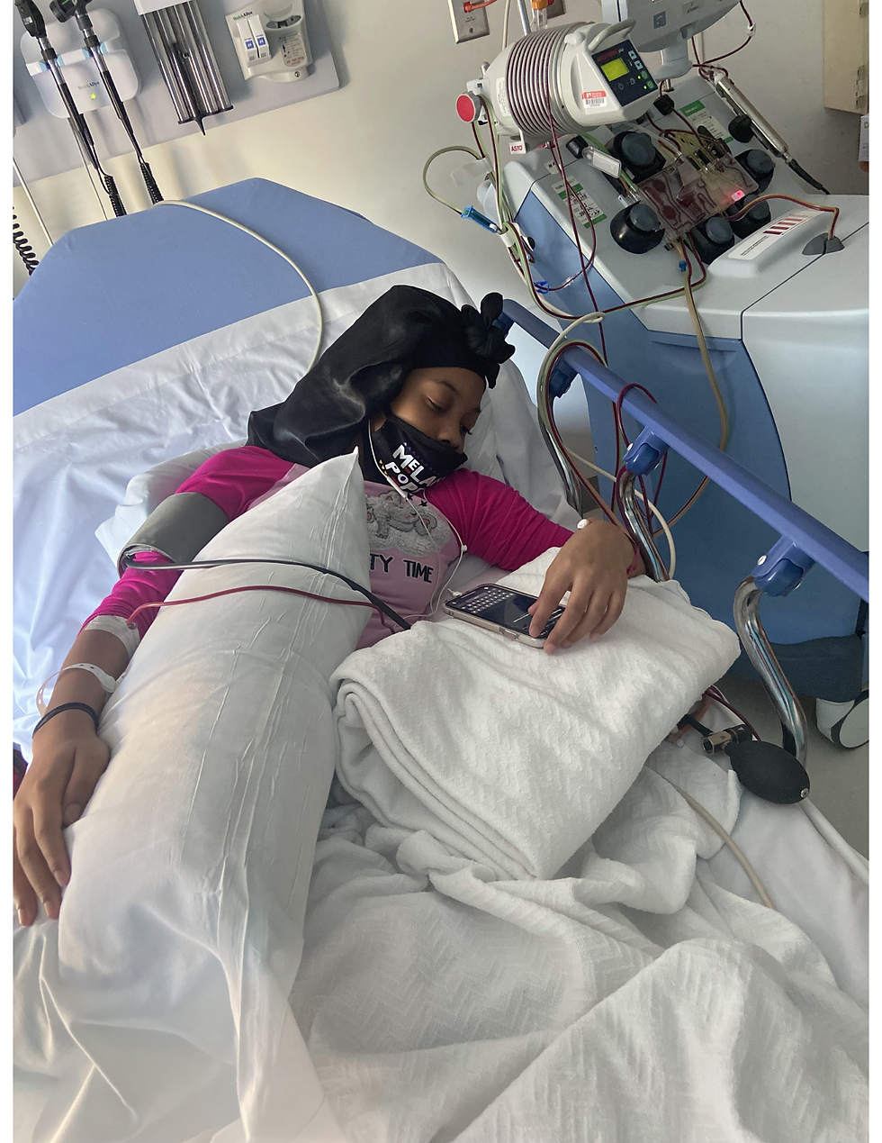This young warrior is getting a blood transfusion and fluids while she plays games on her phone to distract herself.