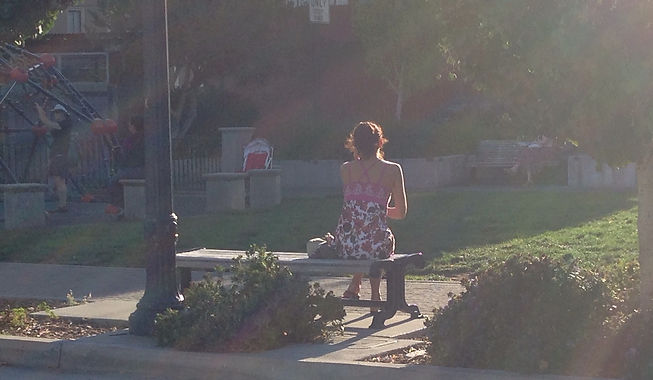 Individual therapy offered by Robert Solley, PhD, in San Francisco is represented by woman in floral-print dress sitting alone on a bench, seen from behind.