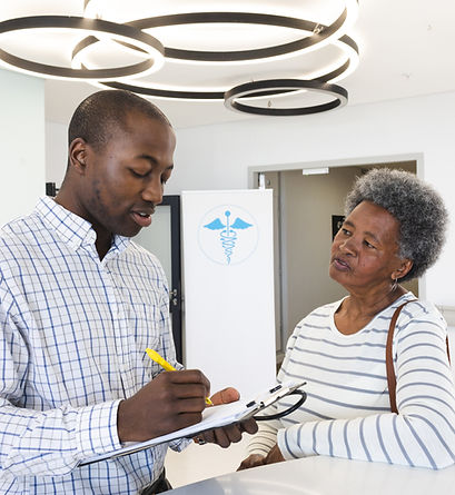 african-american-male-doctor-taking-notes-talking-with-senior-woman-hospital-reception (1)