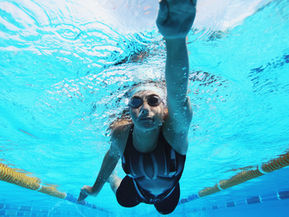 A female swimmer in a pool training for olympics