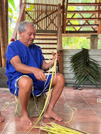Basilio making a hammock from palm leaves.