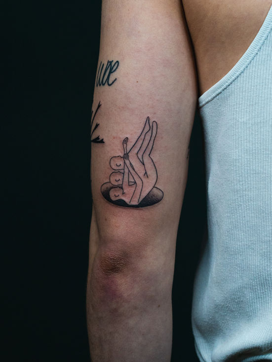 Ignorant Tattoo einer Illusion auf der eine Person mehrmals in ein loch fällt auf dem hinteren Oberarm eines Mannes vor einem schwarzen Hintergrund