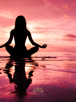 Una mujer meditando en la playa