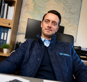 Man in blue quilted jacket at office desk