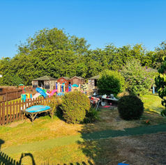 Outdoor play area in a grassy gallery garden under a clear blue sky