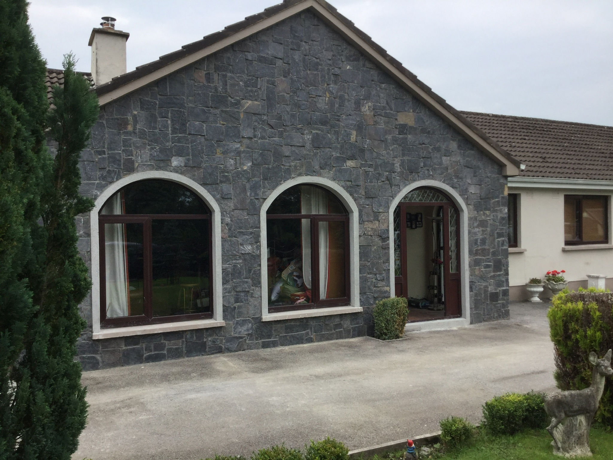 Black limestone building facade with arched windows
