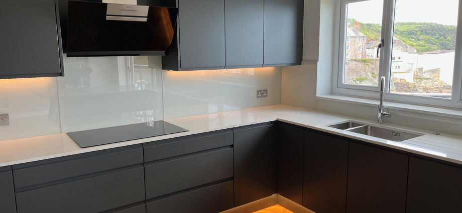 Modern kitchen with dark cabinets, light counters, sink