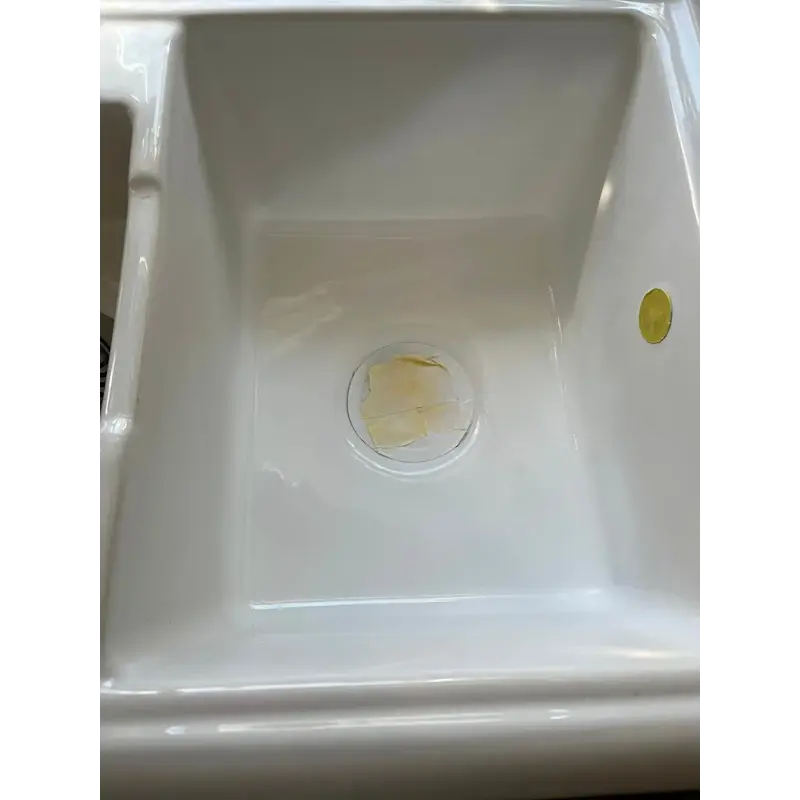 A man inspecting a clean, white bathtub in a modern bathroom setting.