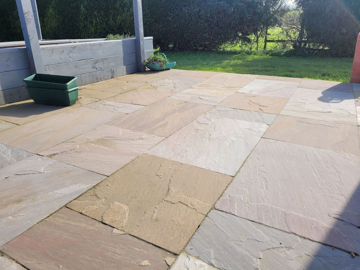 Outdoor patio with flagstone paving and a green planter