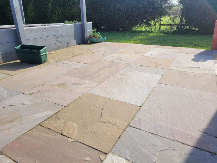 Outdoor patio with flagstone paving and a green planter