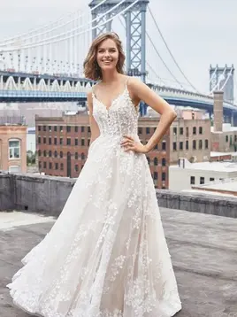 Woman in MADISON JAMES lace gown on rooftop with bridge