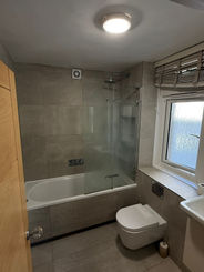 Modern bathroom with bathtub, toilet, and window