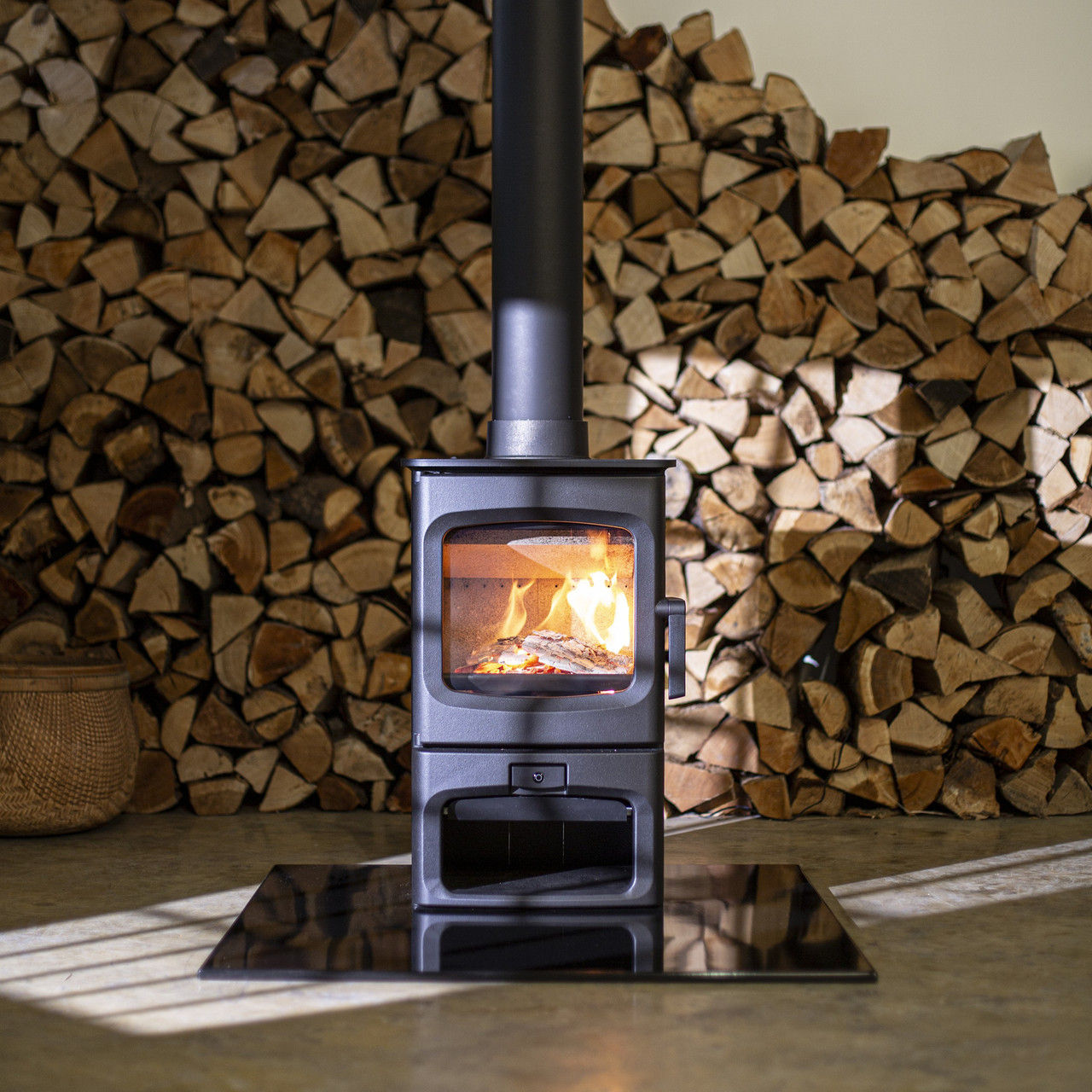 Charnwood Aire 300 woodburning stove with stacked logs.