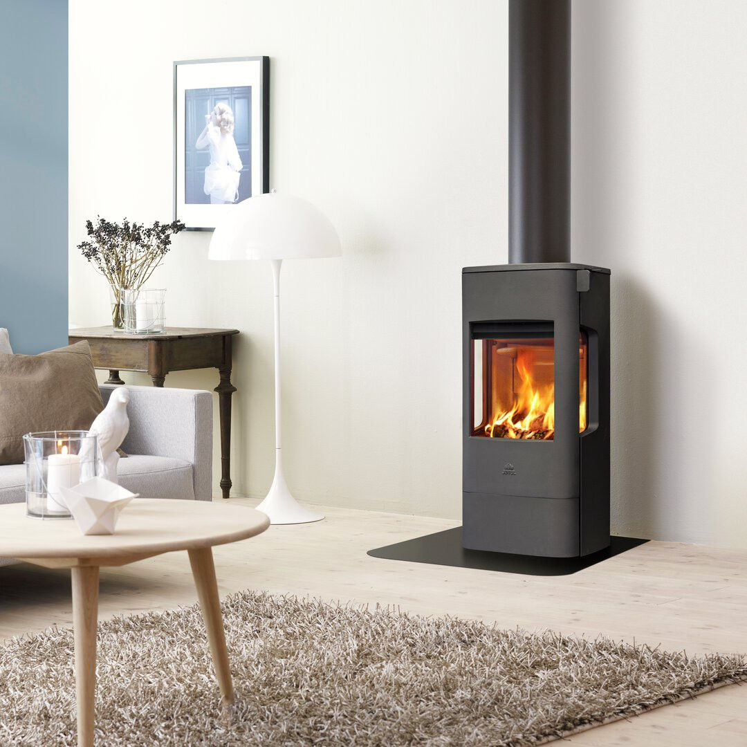 Jotul F233 wood burning stove with glass sides in a living room.