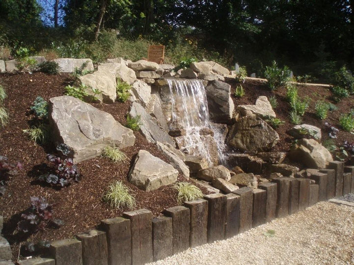 Landscaped garden with rock waterfall and wooden wall