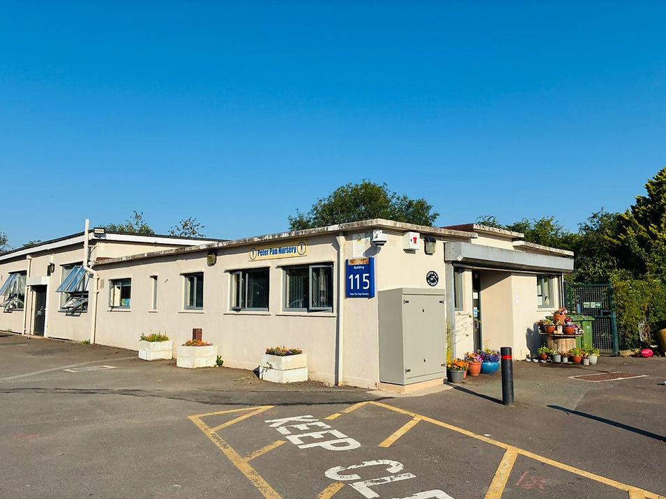 Small white one-story building with blue signage under a clear sky.