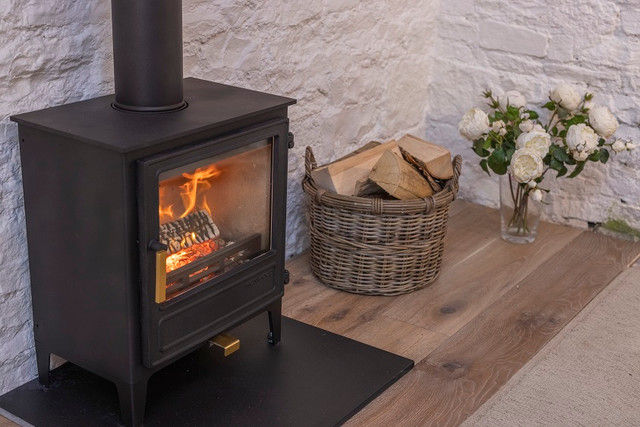 Thumbnail: Ironwood Thaw 5kw woodburning stove in a rustic fireplace