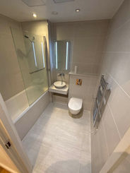 Modern bathroom with tub, toilet, and sink