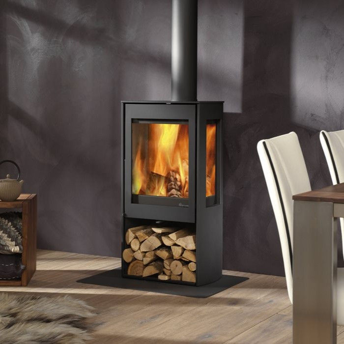 Dik Geurts Kalle woodburning stove with fire and log storage.