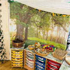 Classroom nature corner with forest backdrop and play baskets
