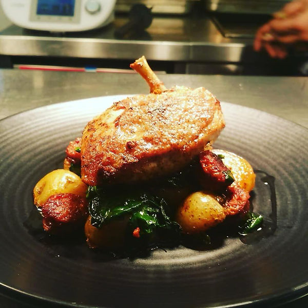 Roasted chicken leg with baby potatoes and sautéed greens