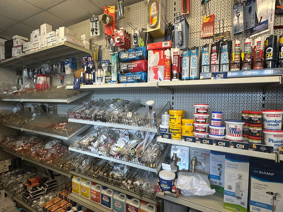 Assorted metal plumbing parts and fittings arranged neatly on a grey surface.