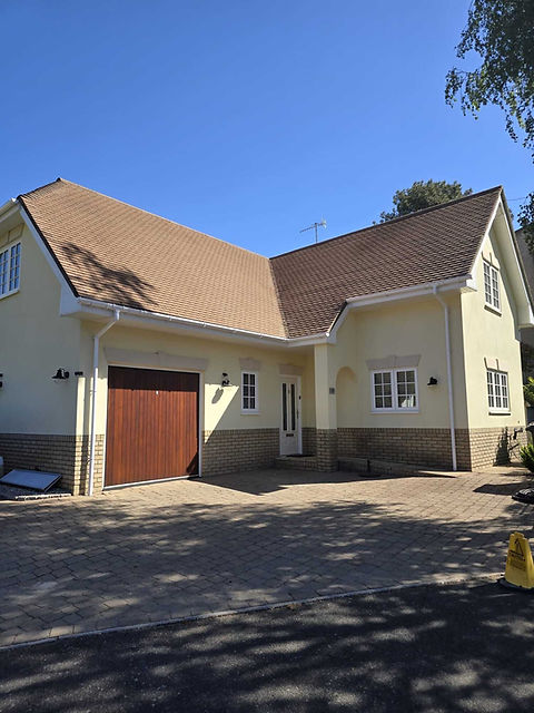 Clean brown roof on a yellow two-story house