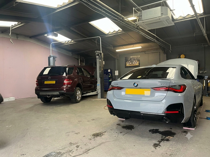 BMW and SUV inside a garage for car servicing