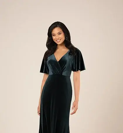 Woman in dark green velvet gown with flutter sleeves