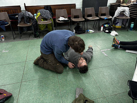 Instructor performing CPR training on a participant during a first aid course