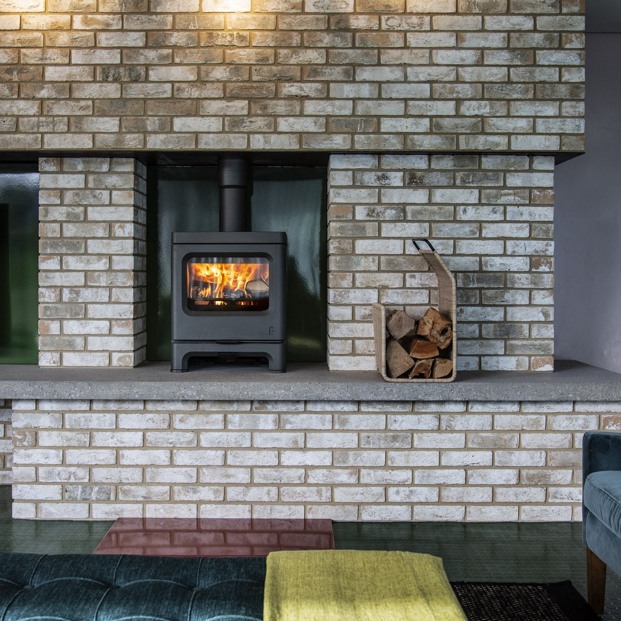 Charnwood Skye 7 low stove in black against a brick wall