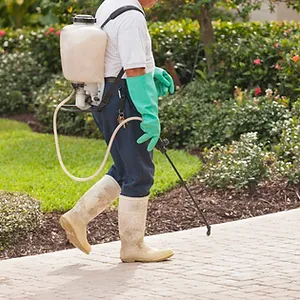 Pest control technician using portable spray rig