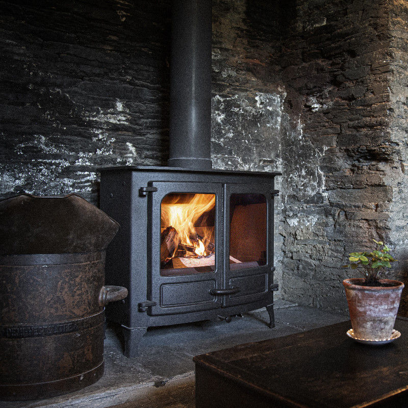 Charnwood Island III 12kW wood burning stove in stone room.