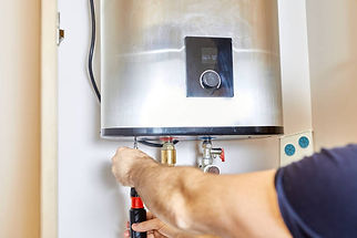 Technician using a screwdriver to repair a water heater