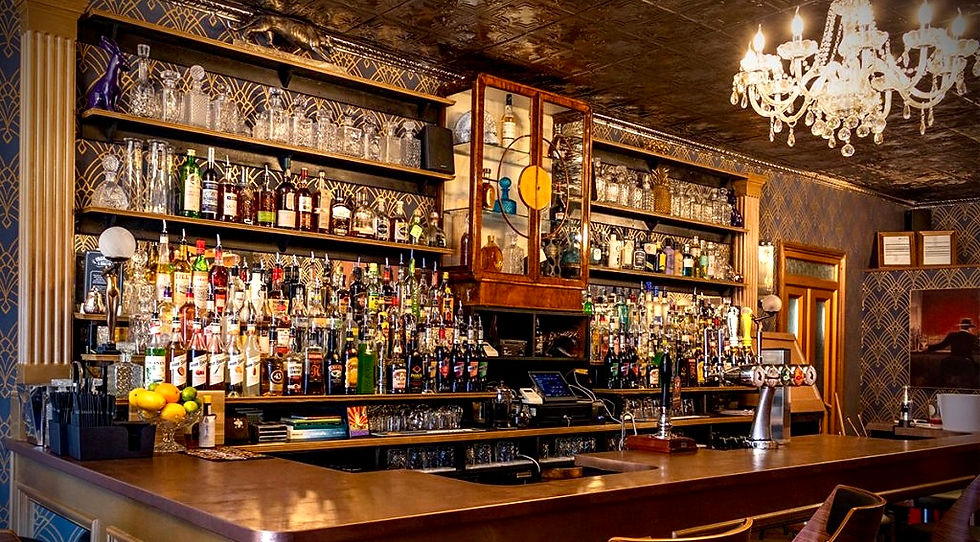 Bar counter with shelves of alcohol bottles and glassware