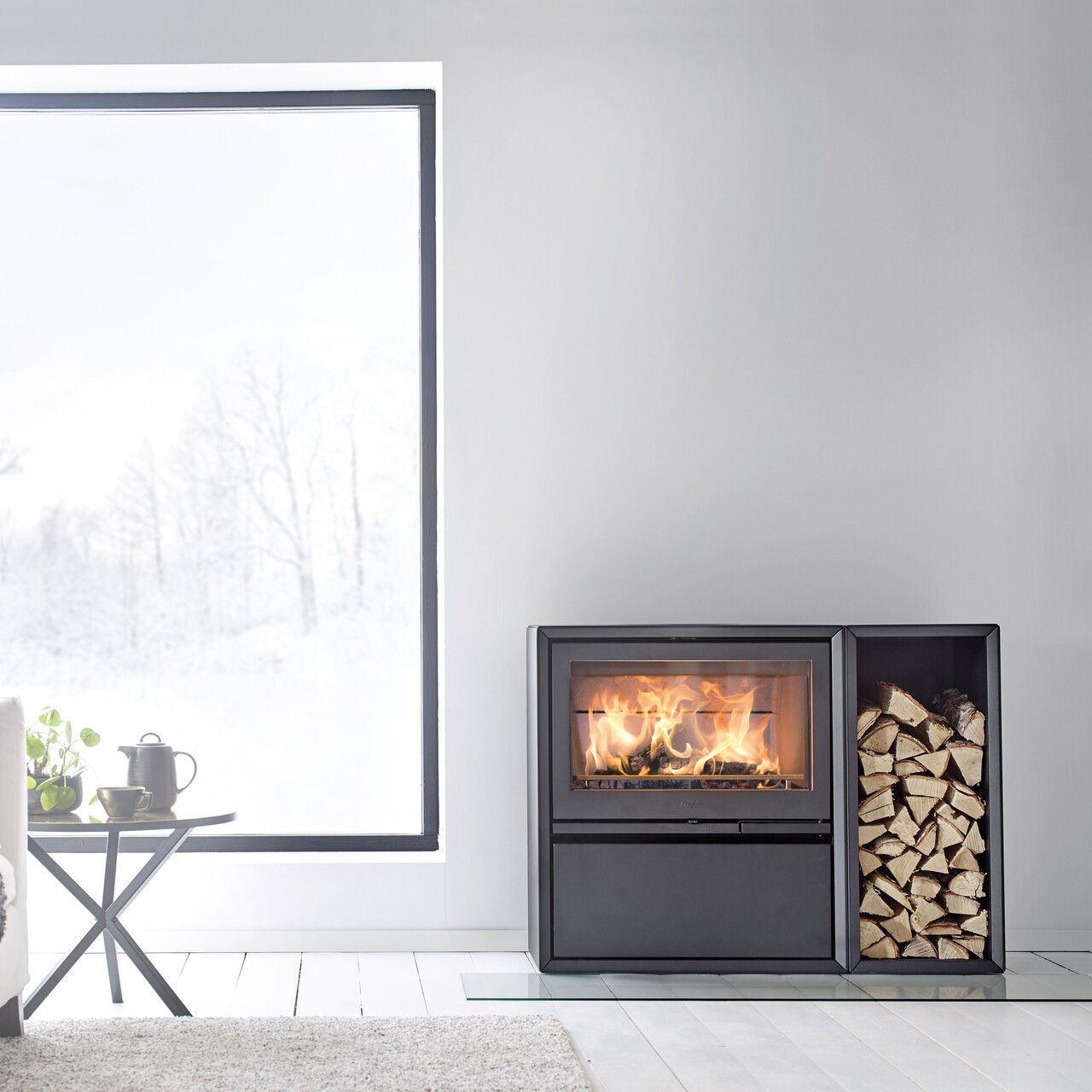 Contura 310 wood burning stove with burning fire and log store