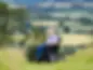 Man in powered wheelchair on a grassy hill