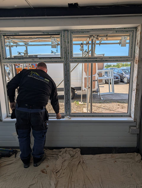 Worker installing commercial windows in a new building.