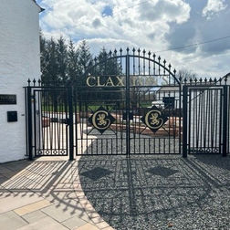 black gates next to a white house