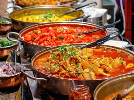 ive large dishes filled with different types of curry, each with a distinct color and texture, showcasing a variety of vibrant and flavorful Indian cuisine.