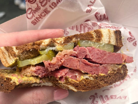 Thick salt beef sandwich on buttered bread with pickles, juicy meat layers close-up, perfect street food image.