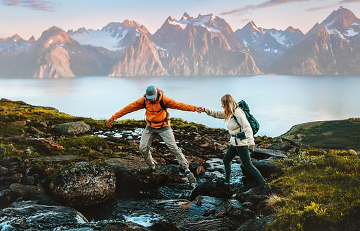 Couple Hiking in Norway together with mountains and a fjord in the background
