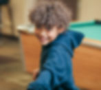 Boy playing pool smiling