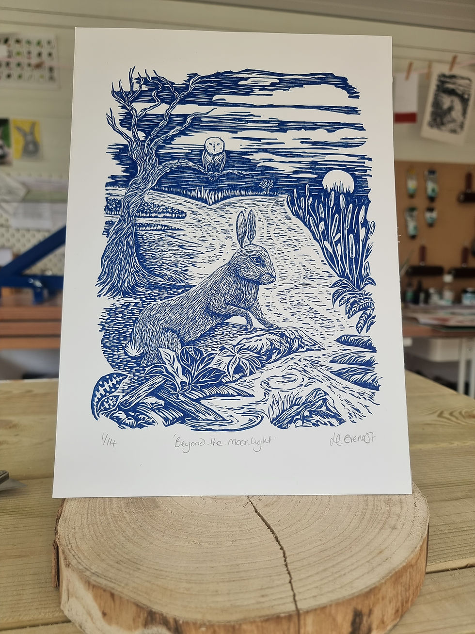 Thumbnail: Beyond the Moonlight original linocut print of a large rabbit looking out into the midnight sky linocut print, in royal blue