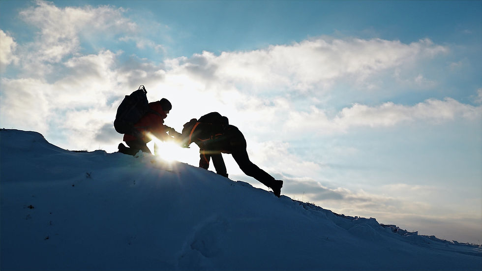 Two climbers helping each other on the slopes, whilst climbing Kilimanjaro.