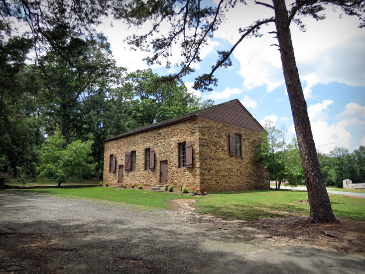 A brown stone church with brown shuttered windows