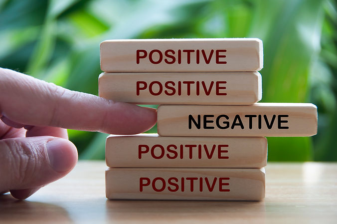 hand-pushing-out-negative-out-from-positive-text-wooden-blocks.jpg