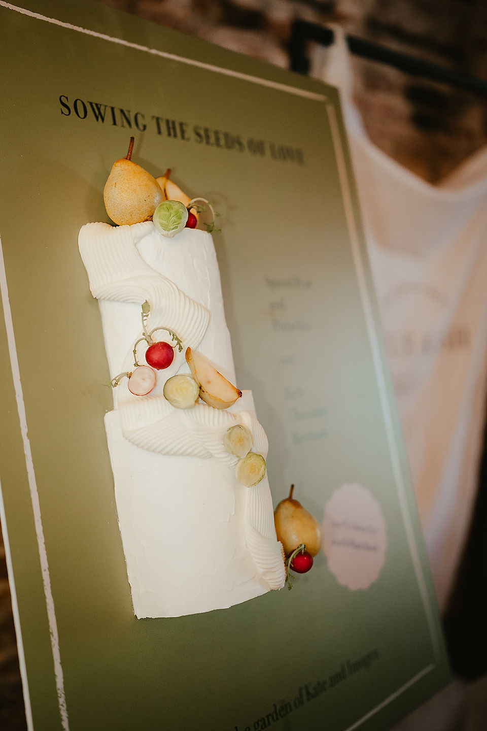 Poster on an easel features a wedding cake with pears and radishes at Godwick Hall