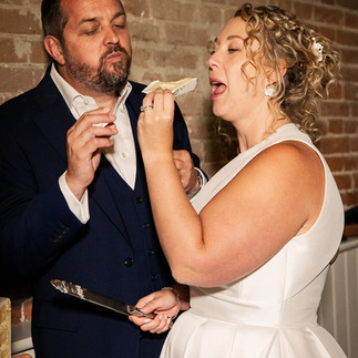 A happy couple enjoys eating their Dutch-themed wedding cake