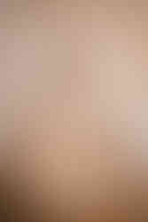 stacked brown marble effect wedding cake agaisnt a draped wedding ceremony area